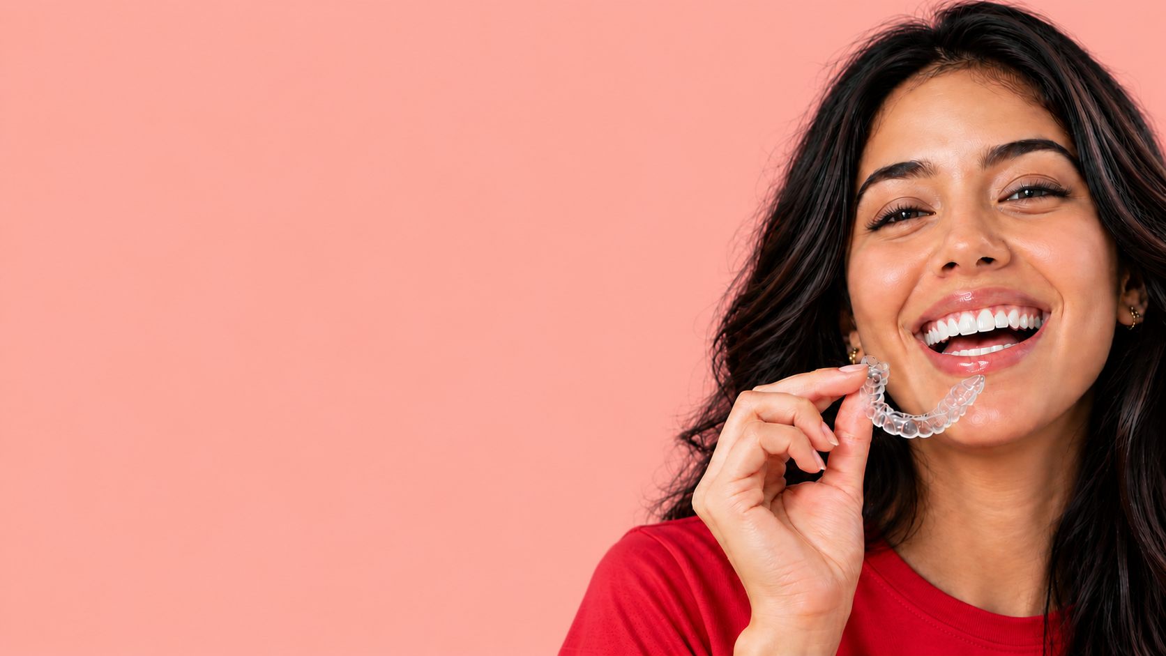 Mujer sonriendo con un alineador transparente en la mano
